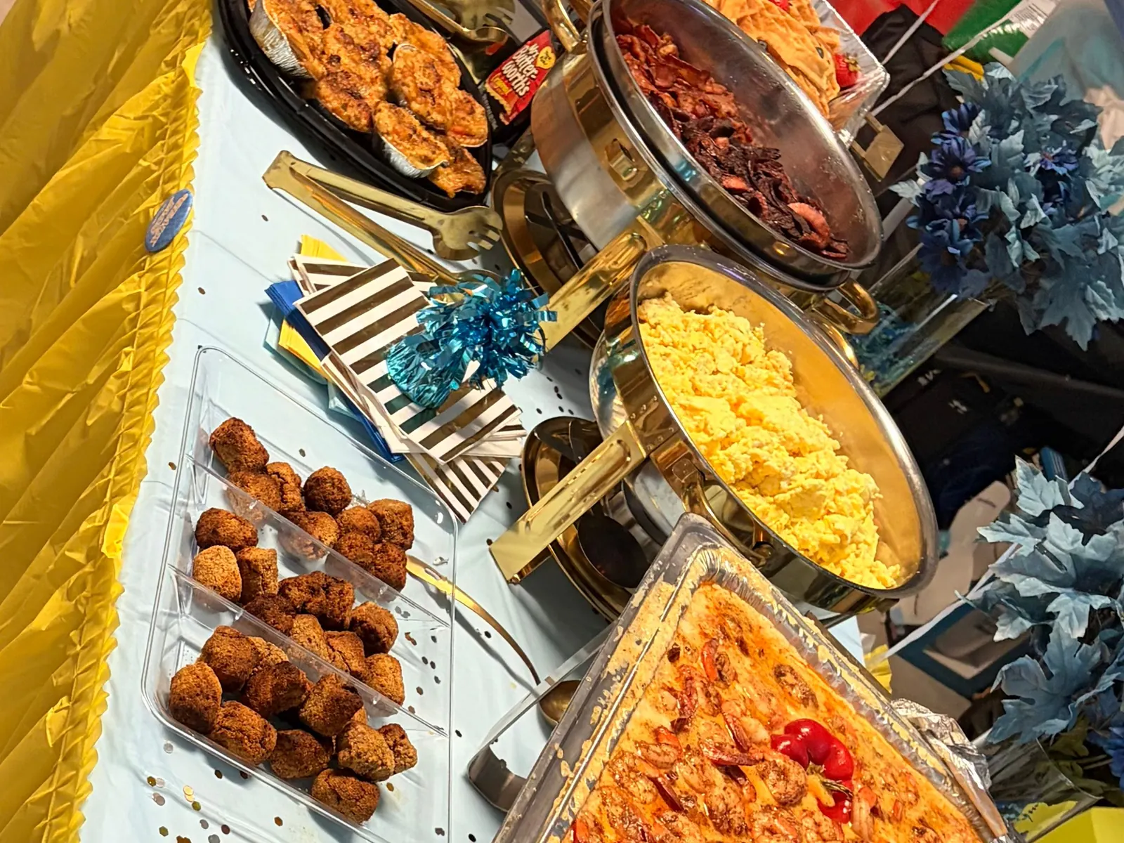 A Bayou Fork Kitchen catering spread with scrambled eggs, bacon, fried bites and shrimp and grits